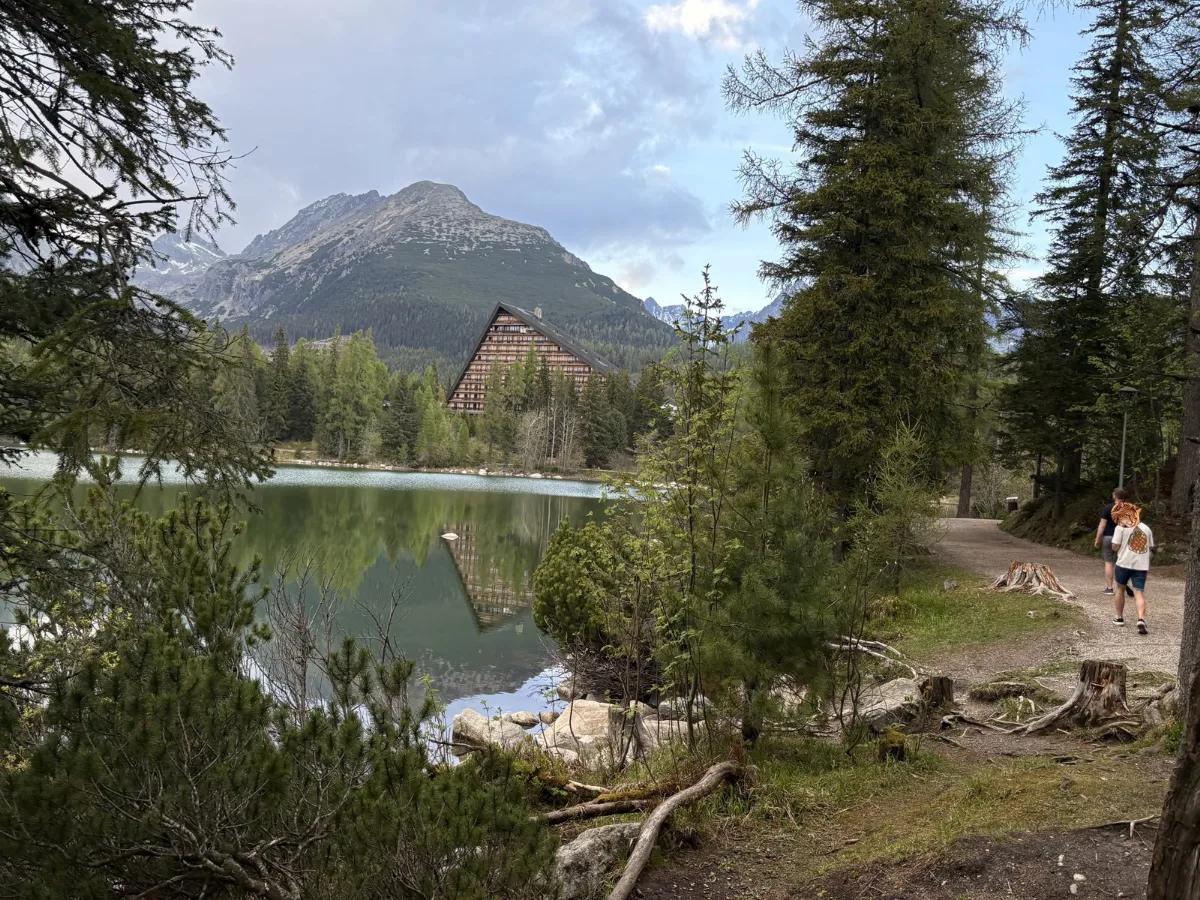 湖畔步道,遠方是尖尖的山峰,林間可以看到湖邊的旅館建築。