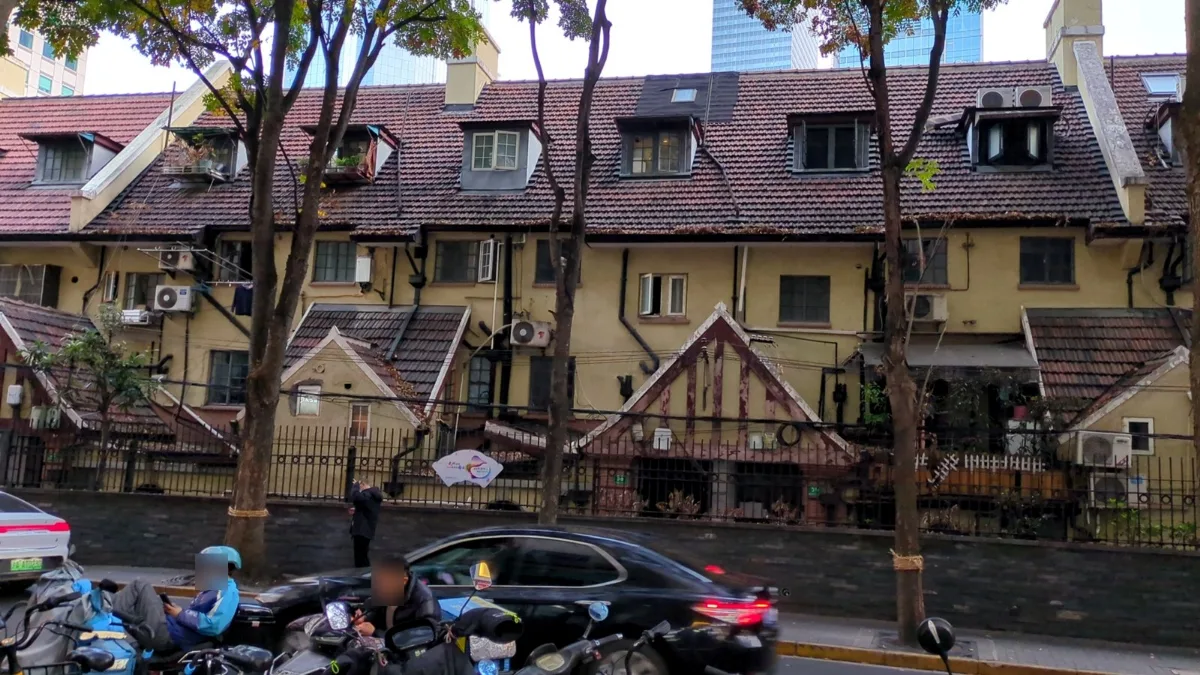 街邊紅瓦斜屋頂的老洋房，路邊停滿了機車。