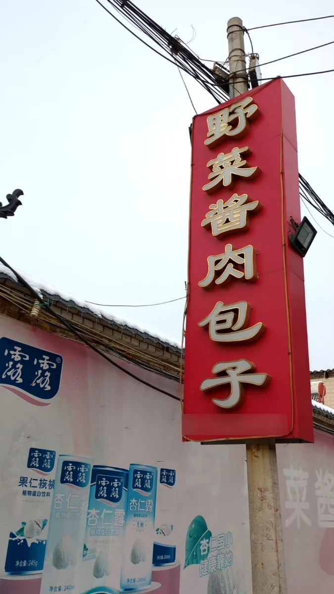 紅色直立招牌「野菜醬肉包子」，在寒風裡看到特別溫暖。