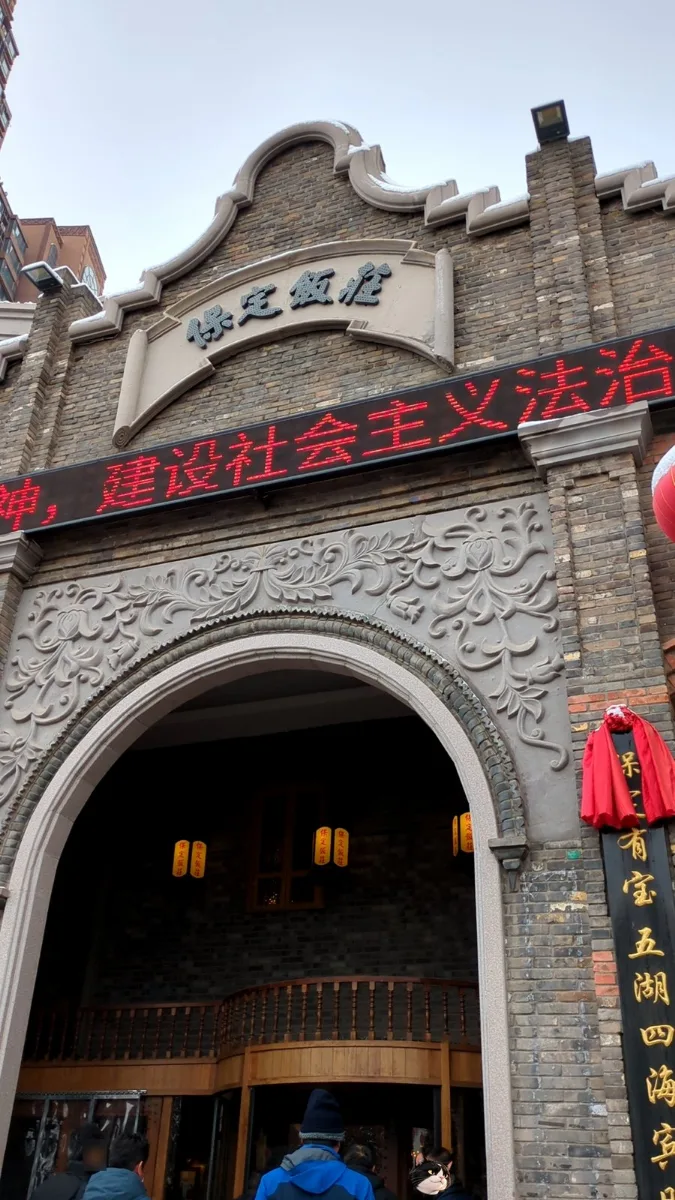 「保定飯店」的磚造門樓，弧形山牆和雕花很有年代感。